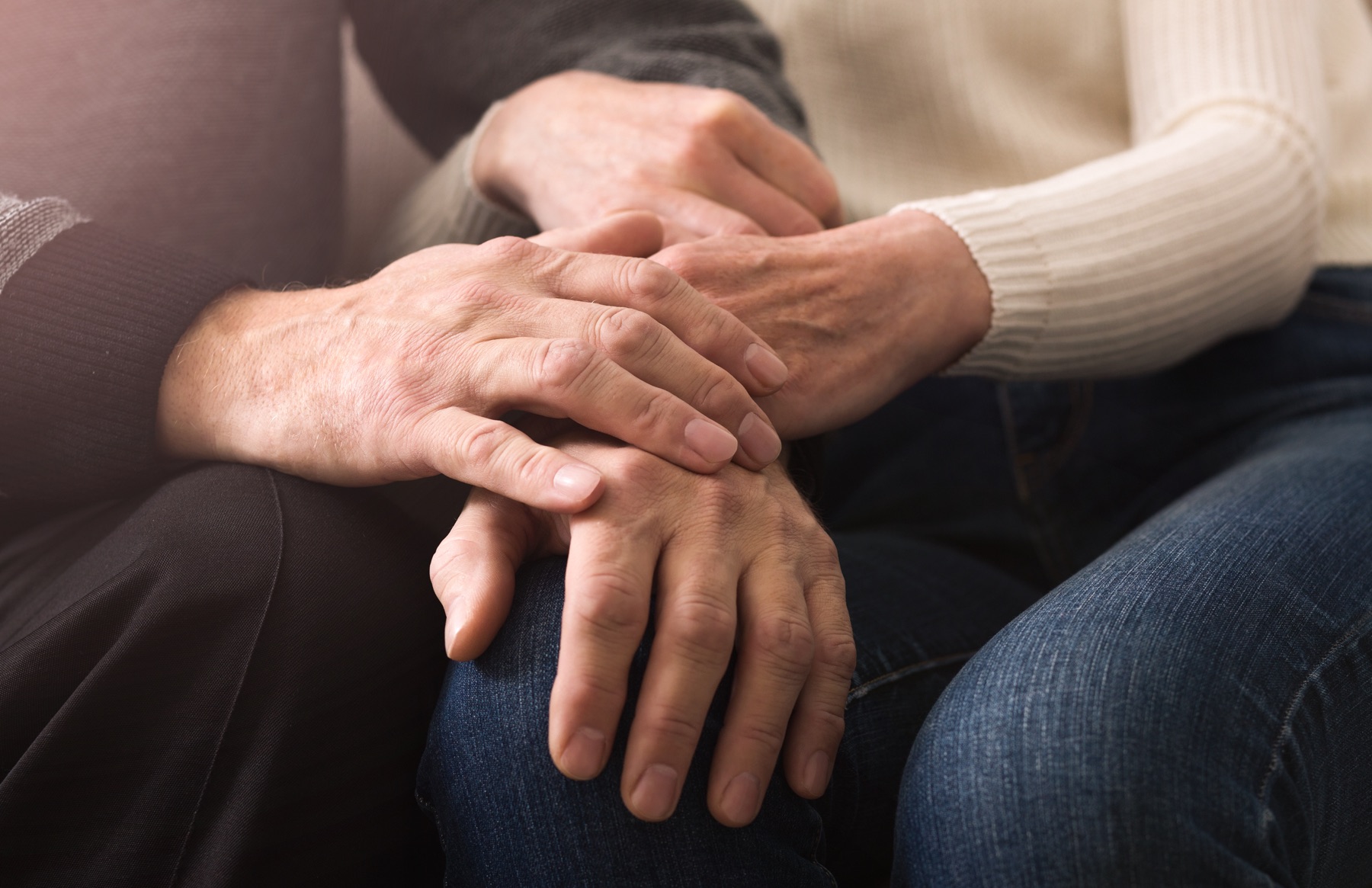 Two people holding hands in support